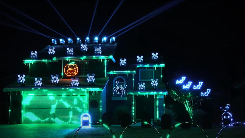 A house lit up with Halloween lights that flash in sync with the audio and music from the final scene of The Matrix.