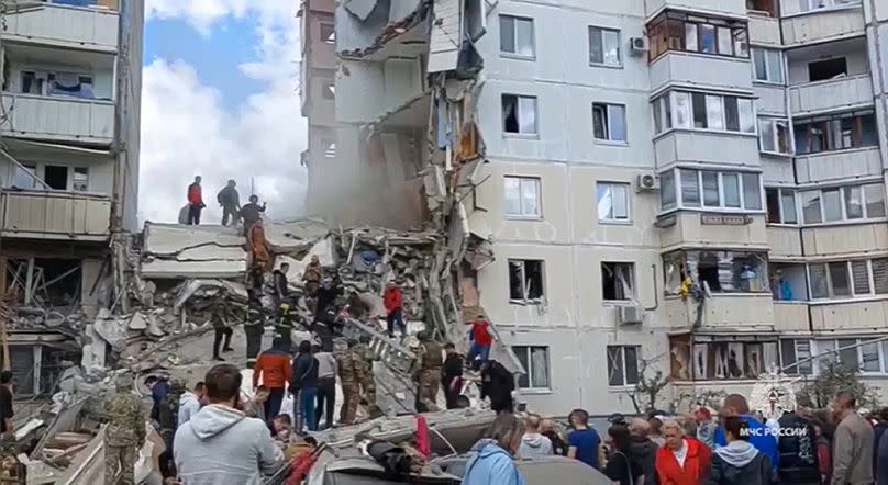 Russian emergency services work at the scene of a partially collapsed block of flats authorities said was hit during an attack by Ukrainian shelling, in Belgorod, Russia