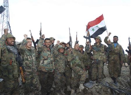 Forces loyal to Syrian President Bashar al-Assad are seen at one of the sites in Latakia mountains after taking control of it from rebel fighters April 3, 2014, in this handout released by Syria's national news agency SANA. REUTERS/SANA/Handout