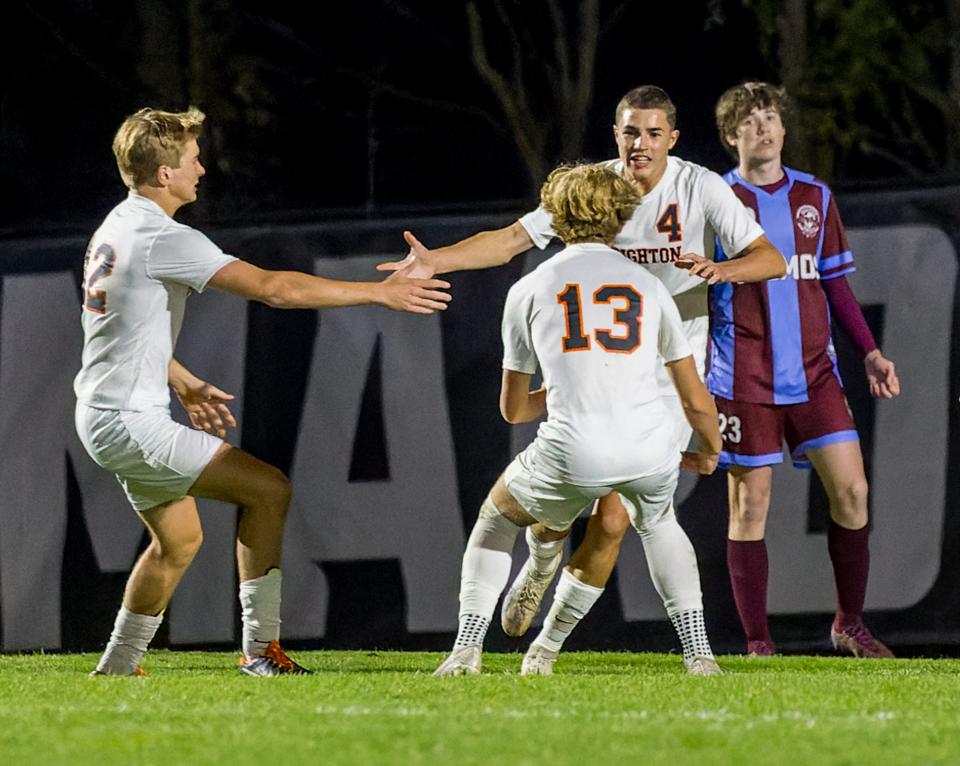 Brighton's Owen Buckley (4) celebrates the lone goal of the night with teammates Andrew Bowman (13) and Ethan Cassar (22) during a 1-0 district soccer victory over Okemos Thursday, Oct. 12, 2023.