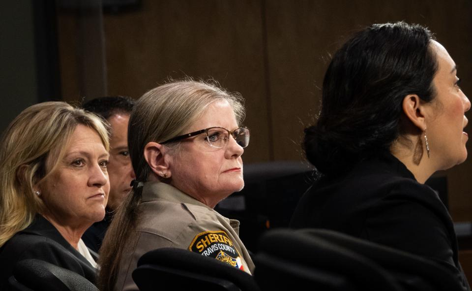 Officials, including Travis County Sherriff Sally Hernandez, center, and 427th Criminal District Court Judge Tamara Needles, left, listen to Travis County Attorney Delia Garza speak ahed of Travis County Commission's vote to begin the development of a new mental and behavioral diversion center in an effort to divert people who are experiencing a mental health episode away from jail at the Travis County Administration building, March 21, 2023.