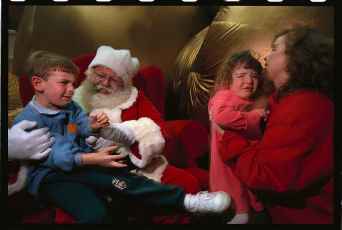 A miserable child in Santa's lap, and another waiting for the chance