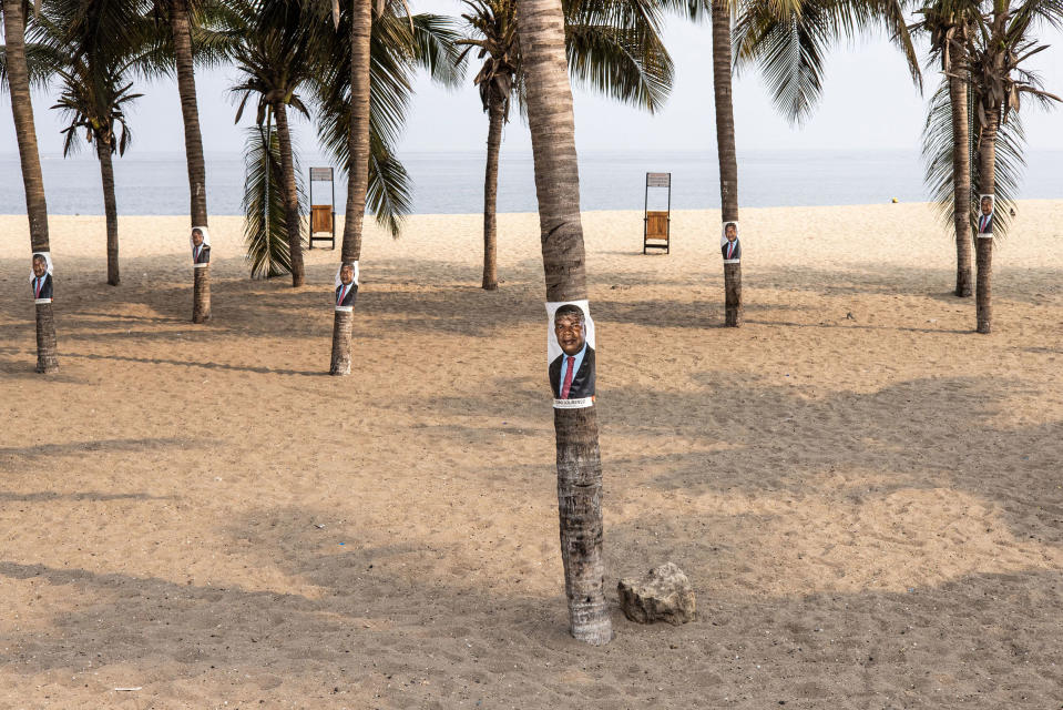 Campaign posters for the current President of Angola, Joao Lourenco, are pictured on palm trees along the beach front in Luanda on Aug. 23.<span class="copyright">John Wessels—AFP/Getty Images</span>