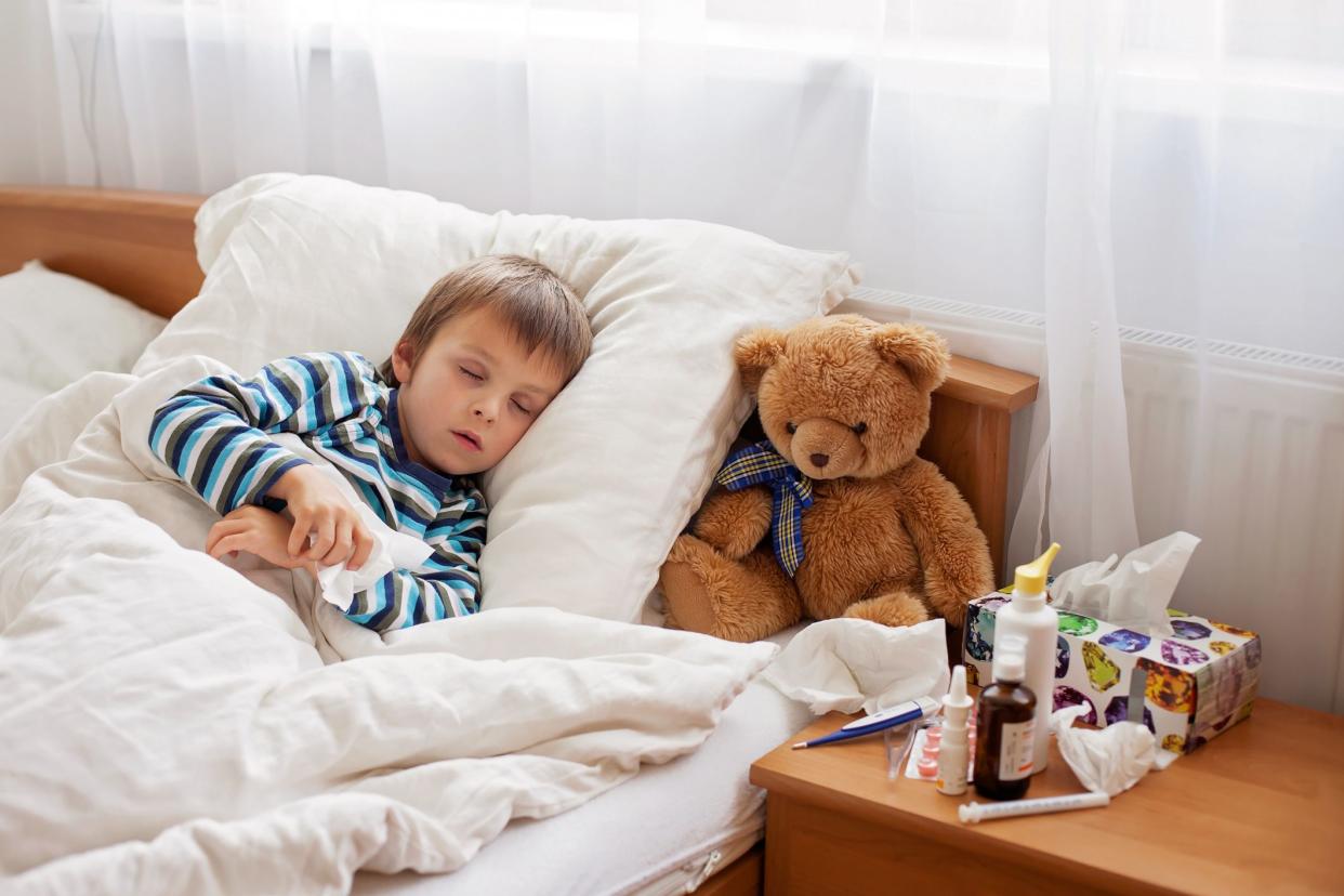 sick boy sleeping with medications on night table