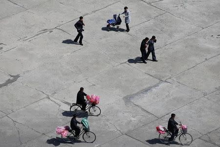 People carry accessories as North Korea prepares to mark Saturday's 105th anniversary of the birth of Kim Il-sung, North Korea's founding father and grandfather of the current ruler, in central Pyongyang, North Korea April 12, 2017. REUTERS/Damir Sagolj