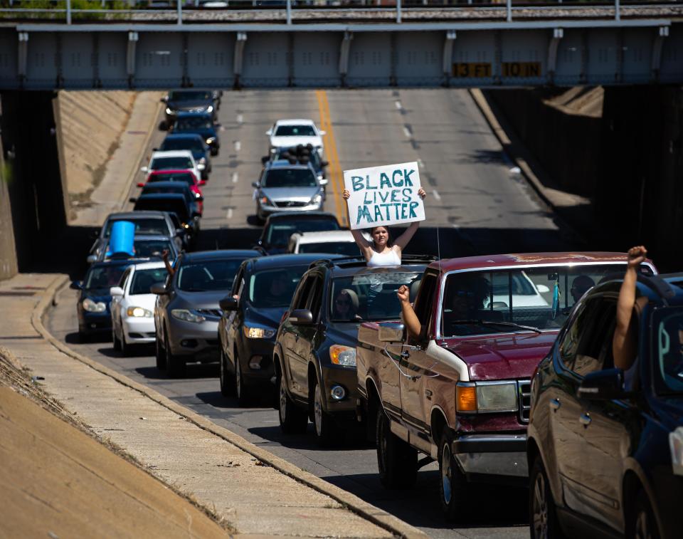 A woman holds a "Black Lives Matter" sign up as cars parade down South Grand Avenue during the Solidarity Vehicle Procession hosted by Black Lives Matters in 2020. Over 3000 cars joined in the procession of cars that was in response to the deaths of Breonna Taylor, Dreasjon Reed and George Floyd, all killed by law enforcement officers. BLM will hold another procession on May 29.