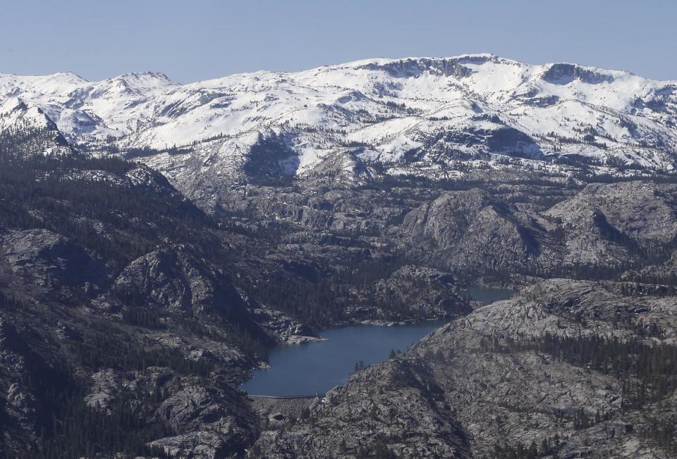 FILE - In this April 28, 2015, file photo, a Sierra Nevada lake in California is surrounded by barren ridges, usually covered in snow that time of year, during an aerial survey of the snowpack done by the California Department of Water Resources. California state water managers are measuring the Sierra Nevada snowpack Wednesday, Mar. 1, 2017, in a third reading of the year, shaping up to be California's wettest winter on record. (AP Photo/Rich Pedroncelli, File)