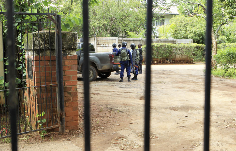 Armed police officers stand outside the residence of Evan Mawarire, an activist and pastor who helped mobilize people to protest against the hike in fuel prices, following his arrest in Harare, Zimbabwe, Wednesday, Jan. 16, 2019. Mawarire was arrested Wednesday for allegedly inciting violence in the protests against the government's increase in fuel prices. (AP Photo/Tsvangirayi Mukwazhi)