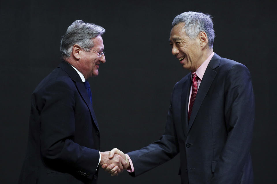 Singaporean Prime Minister Lee Hsien Loong, right, shakes hands with International Institute for Strategic Studies (IISS) director-general and chief executive John Chipman before delivering a keynote address during the opening dinner of the 18th IISS Shangri-la Dialogue, an annual defense and security forum in Asia, in Singapore, Friday, May 31, 2019. (AP Photo/Yong Teck Lim)