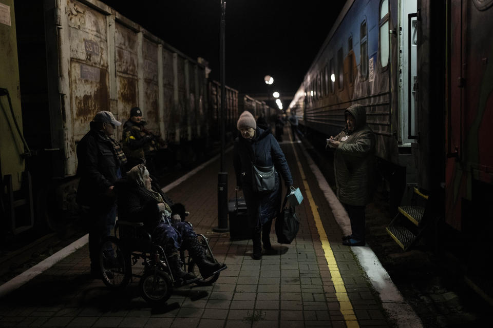 Ukrainians board the Kherson-Kyiv train at the Kherson railway station, southern Ukraine, Monday, Nov. 21, 2022. Ukrainian authorities are evacuating civilians from recently liberated sections of the Kherson and Mykolaiv regions, fearing that a lack of heat, power and water due to Russian shelling will make conditions too unlivable this winter. The move came as rolling blackouts on Monday plagued most of the country. (AP Photo/Bernat Armangue)