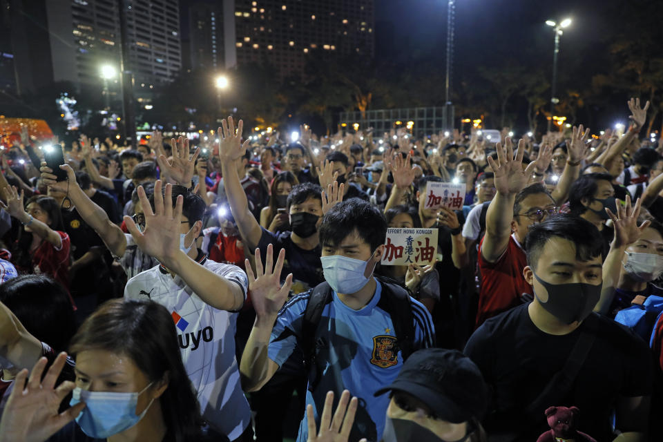 Pro-democracy football fans gather to form a human chain as they sing songs at Victoria Park in Hong Kong, Wednesday, Sept. 18, 2019. An annual fireworks display in Hong Kong marking China's National Day on Oct. 1 was called off Wednesday as pro-democracy protests show no sign of ending. (AP Photo/Kin Cheung)