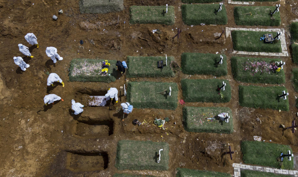 In an aerial view, workers bury a coffin containing the body of a COVID-19 victim at a cemetery reserved for those who died of complications related to coronavirus in Medan, North Sumatra, Indonesia, Sunday, May 2, 2021. (AP Photo/Binsar Bakkara)