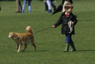 <p>Looking casual in a Barbour jacket, jeans, and wellies, a young Prince William walks a pet dog while at the polo grounds in Cirencester in 1987. </p>