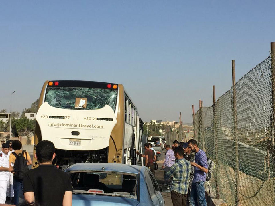 CORRECTS DATE PHOTO TAKEN - A bus and a car are parked after being damaged by a bomb, in Cairo, Egypt, Sunday, May 19, 2019. Egyptian officials say a roadside bomb has hit a tourist bus near the Giza Pyramids. They said Sunday’s blast wounded at least 17 people including tourists. (AP Photo/Mohammed Salah)