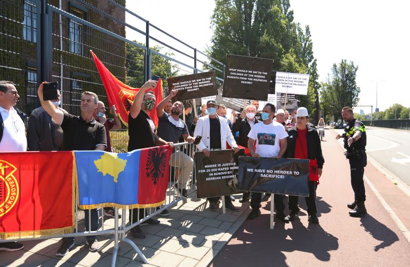 People hold signs as show support for Kosovo's President Hashim Thaci in front of the special tribunal, in The Hague