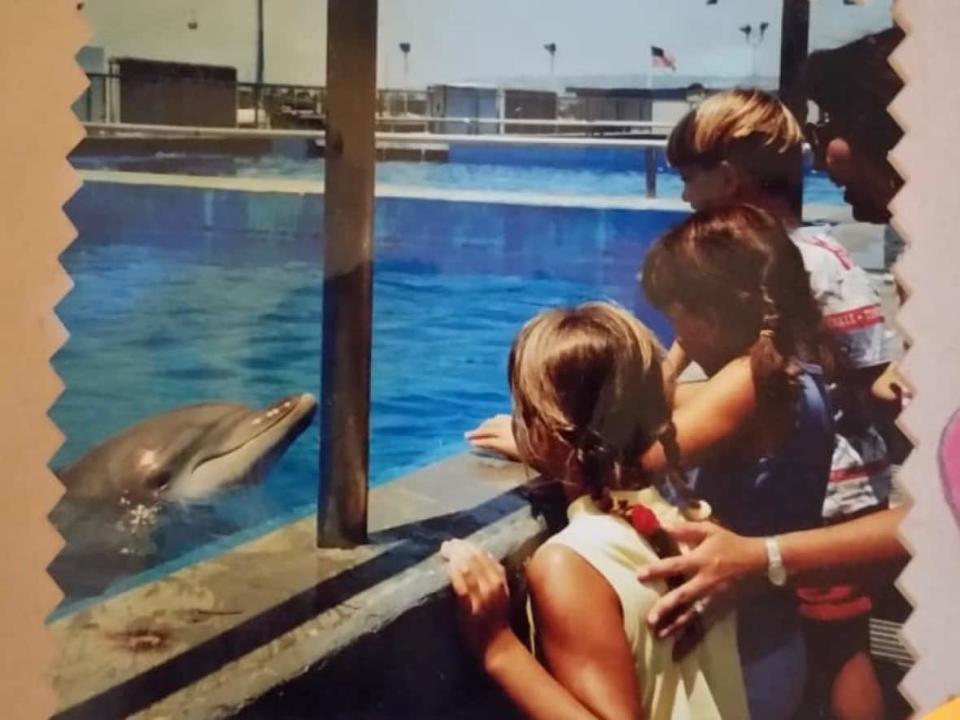 Five-year-old Gina Lonati, centre, in blue, at Sea World years ago, with her cousins Lindsey, left, Nick, right, and her mom. Lonati says her career path was forged the instant she saw that dolphin. (Submitted by Gina Lonati - image credit)