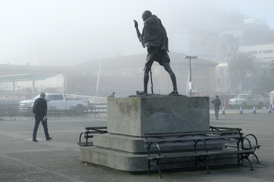 A man walks through the near empty Ferry Building Plaza past a statue of Gandhi Thursday, March 12, 2020, in San Francisco. The plaza is normally occupied with morning commuters and visitors. Gov. Gavin Newsom has issued sweeping, statewide "guidance" in response to the coronavirus pandemic, asking Californians to postpone all non-essential gatherings through the end of March, including even small social gatherings in places where people can't remain at least six feet apart. The vast majority of people recover from the new coronavirus. According to the World Health Organization, most people recover in about two to six weeks, depending on the severity of the illness. (AP Photo/Eric Risberg)