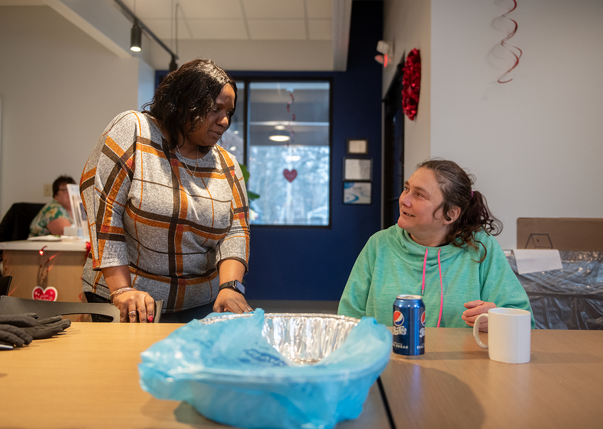 Kent Social Services Program Director Marquice Seward talks with Laura Rabish of Kent during a recent free hot meal.