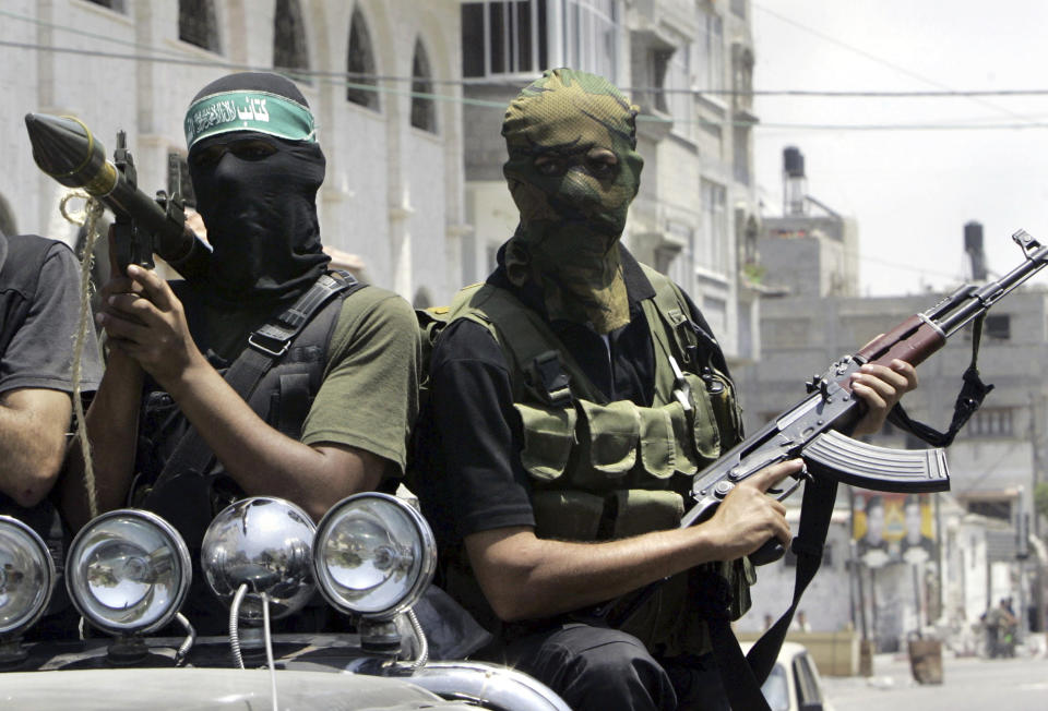 FILE - Palestinian militants from Hamas ride on a truck with their weapons during the funeral of militant Emad Abu Kados who was killed during clashes with Fatah gunmen in the Sheikh Radwan neighborhood in Gaza City, Wednesday, June 13, 2007. Fierce battles over key security positions spread to central and southern Gaza early Wednesday, with Hamas fighters wresting control of the coastal strip's main road, and took control of a major security compound in the southern Gaza Strip town Khan Younis. (AP Photo/Hatem Moussa, File)