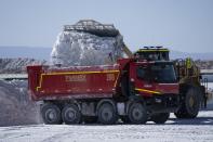 An excavator dumps salt used as part of lithium processing, into a truck at the Albemarle lithium mine in Chile's Atacama desert, Monday, April 17, 2023. (AP Photo/Rodrigo Abd)