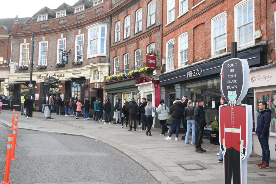 People queue outside Wetherspoon's, King and Castle pub in Windsor, following the further easing of lockdown restrictions in England. Picture date: Friday April 16, 2021.