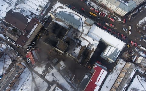 A view of the smoldering shopping centre from above on Monday morning - Credit:  Kirill Kukhmar/ TASS