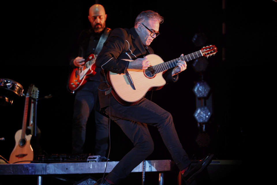 Joselo Rangel, de la banda Café Tacvba, salta al escenario con su guitarra durante un concierto masivo en la Ciudad de México, el sábado 7 de diciembre de 2019. (Foto AP/Anthony Vázquez)