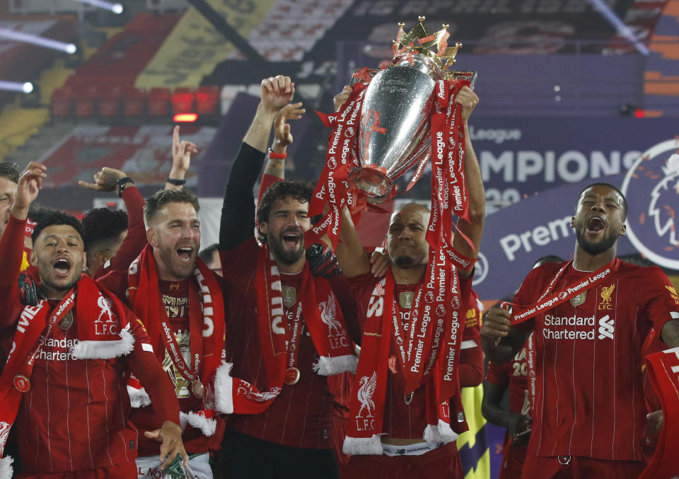 Liverpool's Fabinho and team members celebrate with the English Premier League trophy after it was presented following the Premier League soccer match between Liverpool and Chelsea at Anfield stadium in Liverpool, England, Wednesday, July 22, 2020. (Phil Noble/Pool via AP)