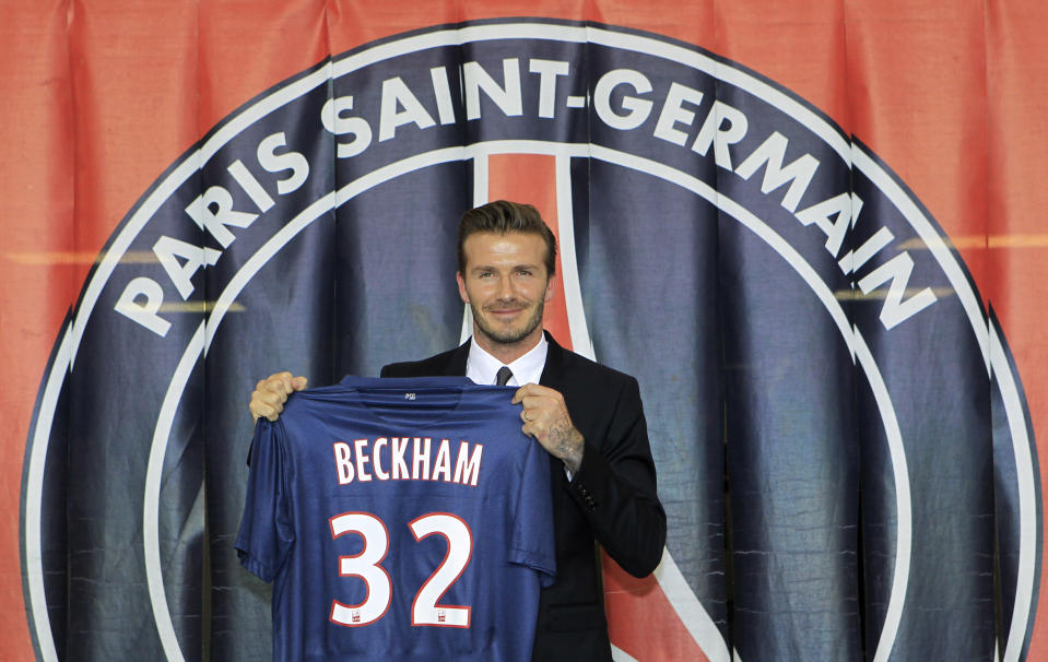 Soccer player David Beckham presents his new jersey after a news conference in Paris January 31, 2013. Former England captain David Beckham has joined Paris St Germain on a five-month contract, the French Ligue 1 club said on Thursday. REUTERS/Gonzalo Fuentes (FRANCE - Tags: SPORT SOCCER MEDIA TPX IMAGES OF THE DAY) - RTR3D75I