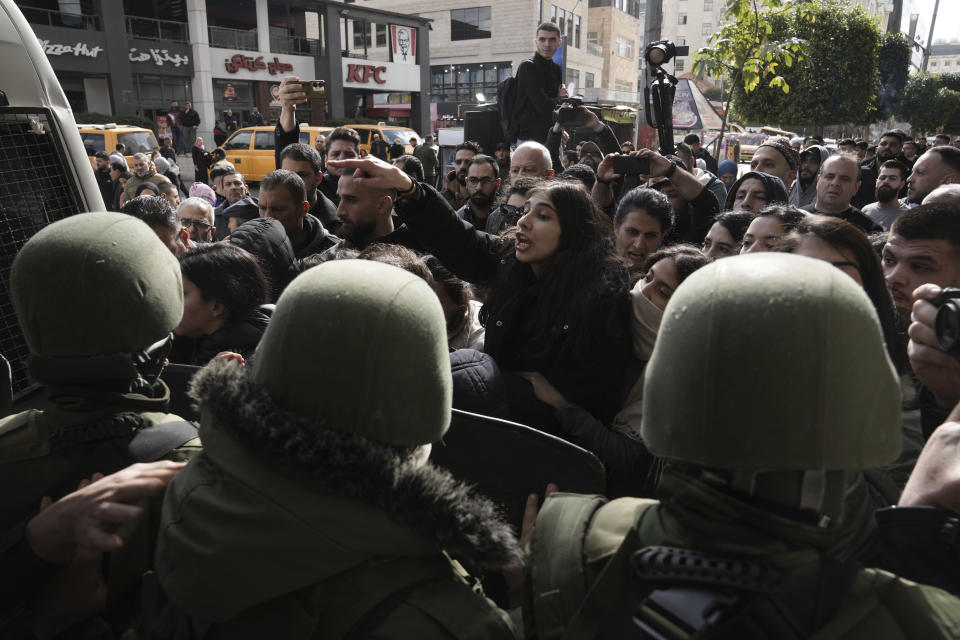 Riot police officers stand guard while Palestinians protest against the visit of U.S. Secretary of State Antony Blinken and his meeting with Palestinian President Mahmoud Abbas in Ramallah, West Bank, Wednesday, Jan. 10, 2024. (AP Photo/Mahmoud Illean)