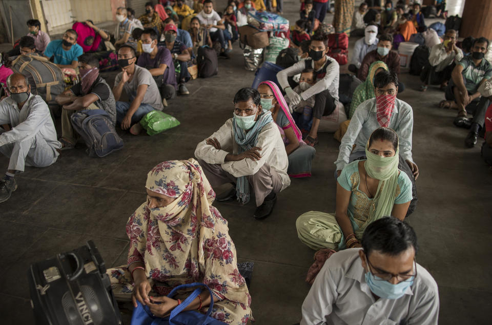 Migrant workers sit at a bus terminal as they wait to catch state-provided transportation to their home villages, in Greater Noida, Uttar Pradesh, on May 29, 2020. Migrant workers, who form part of India's vast informal sector, were the worst hit by the shutdown. Millions lost jobs and incomes.<span class="copyright">Anindito Mukherjee—Bloomberg/Getty Images</span>