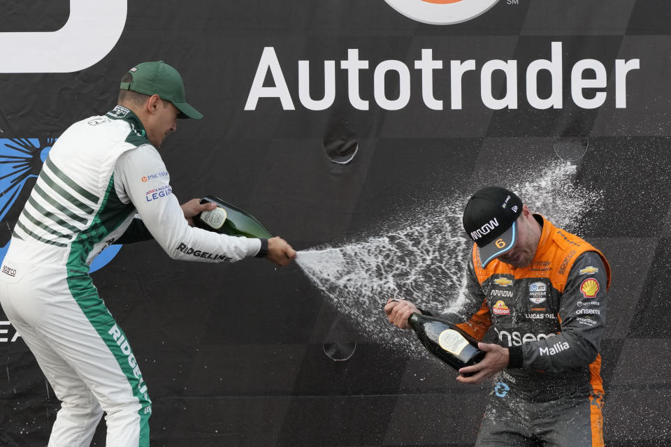 Alex Palou, left, sprays Felix Rosenqvist after winning the IndyCar Detroit Grand Prix auto race, Sunday, June 4, 2023, in Detroit. Rosenqvist took third place. (AP Photo/Carlos Osorio)