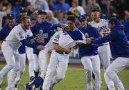 Los Angeles Dodgers' Cody Bellinger celebrates after hitting a walk-off hit during the 13th inning of Game 4 of the National League Championship Series baseball game against the Milwaukee Brewers Tuesday, Oct. 16, 2018, in Los Angeles. The Dodgers won 2-1 to tie the series at 2-2. (AP Photo/Mark J. Terrill)