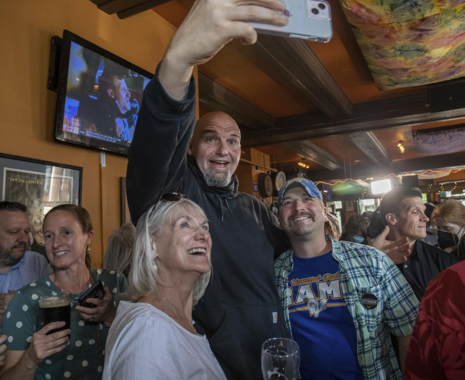 John Fetterman takes a selfie with voters while he campaigns for U.S. Senate at the Holy Hound Tap Room in downtown York, Pa., Thursday, May. 12, 2022. (Mark Pynes/The Patriot-News via AP)