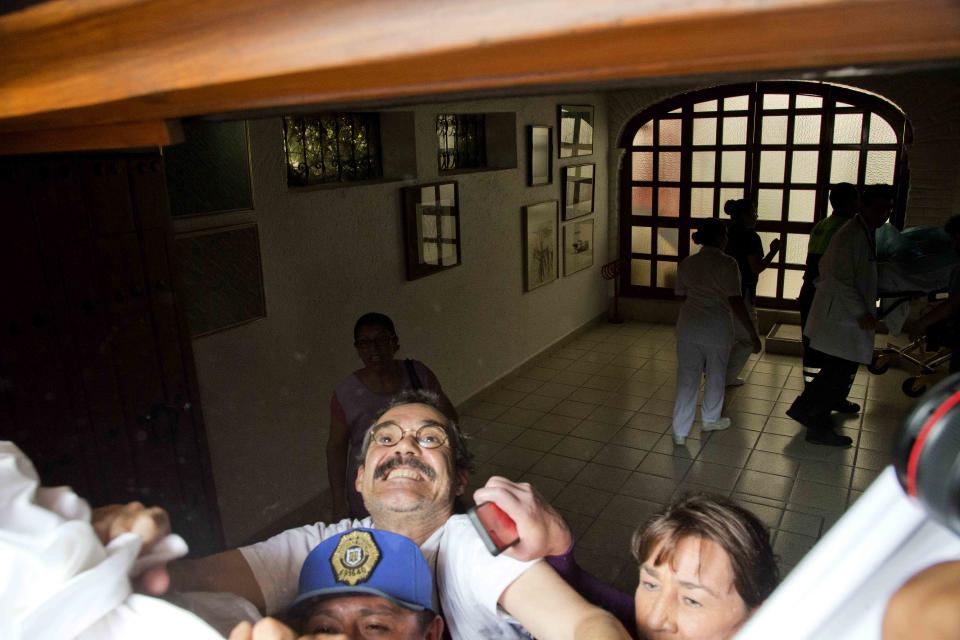 Gonzalo Garcia, the son of Gabriel Garcia Marquez, prevents photographers from taking pictures using a sheet as his father arrives home from the hospital in Mexico City, Tuesday, April 8, 2014. A medical official says the Colombian author and Nobel literature laureate left the hospital where he was treated for eight days for pneumonia and related problems. (AP Photo/Eduardo Verdugo)
