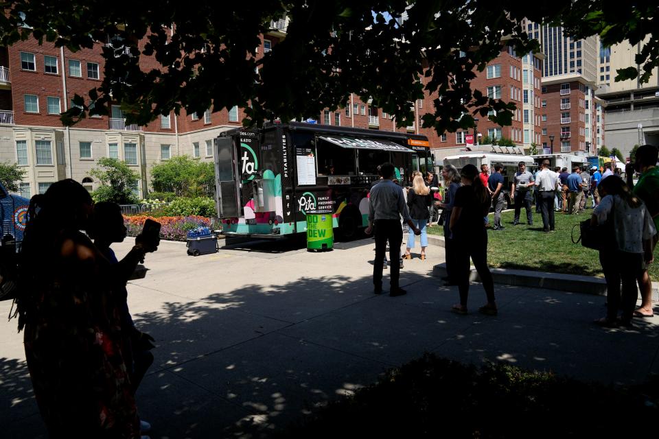 Visitors seek refuge under shady trees while others line up for a tasty treat from the Pitabillies food truck.