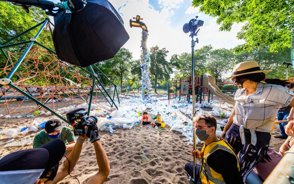 Van Wong photographs his nephew Kody playing among the giant faucet's excessive plastic runoff.