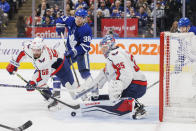 Toronto Maple Leafs defenseman Rasmus Sandin (38) looks for a rebound as Washington Capitals defenseman Erik Gustafsson (56) tries to clear the puck in front of goaltender Darcy Kuemper (35) during the second period of an NHL hockey game in Toronto on Sunday, Jan. 29, 2023. (Cole Burston/The Canadian Press via AP)