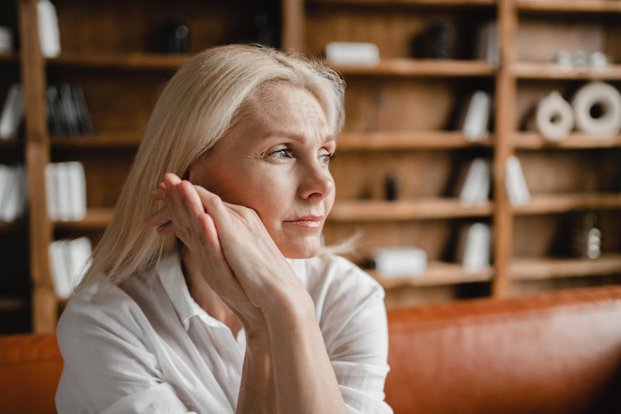 Stressed sad tired exhausted caucasian middle-aged perimenopause mature businesswoman freelancer relaxing on the couch sofa, thinking about family marriage work problems at work office