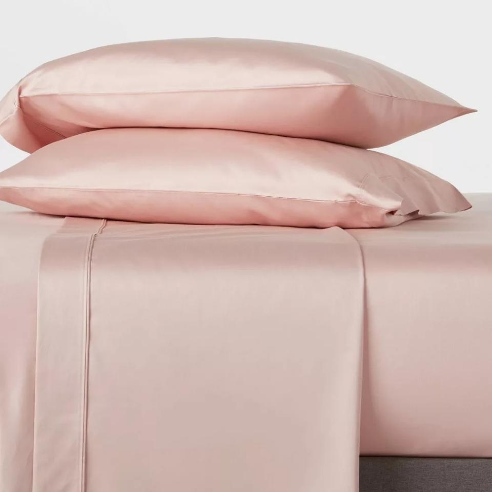 the pink sheets on a bed and two pillows