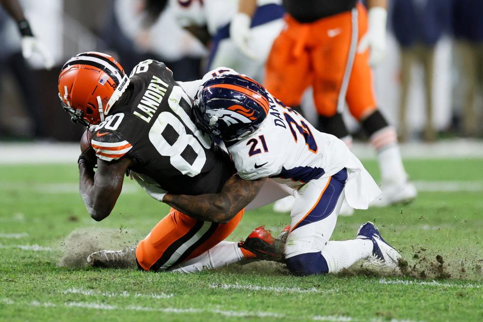 Denver Broncos cornerback Ronald Darby (21) tackles Cleveland Browns wide receiver Jarvis Landry (80) during the second half of an NFL football game, Thursday, Oct. 21, 2021, in Cleveland. (AP Photo/Ron Schwane)