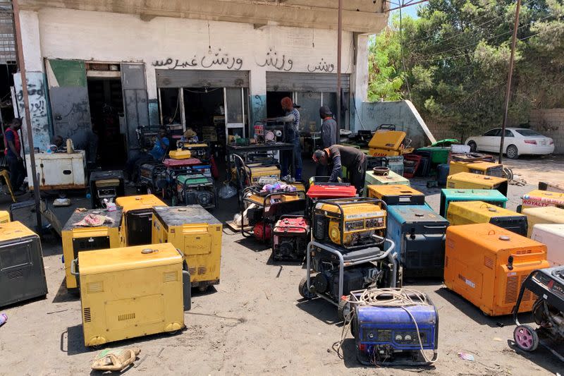 Workers fix generators at a workshop during the long-lasting power blackouts, in Misrata