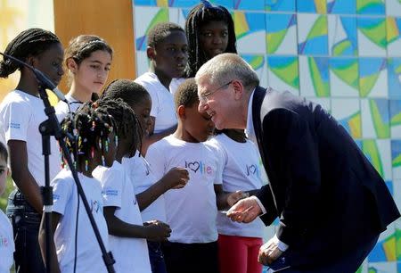 International Olympic Committee President Thomas Bach, right, visits with members of a children's choir during a Olympic Truce inauguration ceremony in athletes village in advance of the 2016 Olympic Games in Rio de Janeiro, Brazil, August 1, 2016. REUTERS/Patrick Semansky/Pool