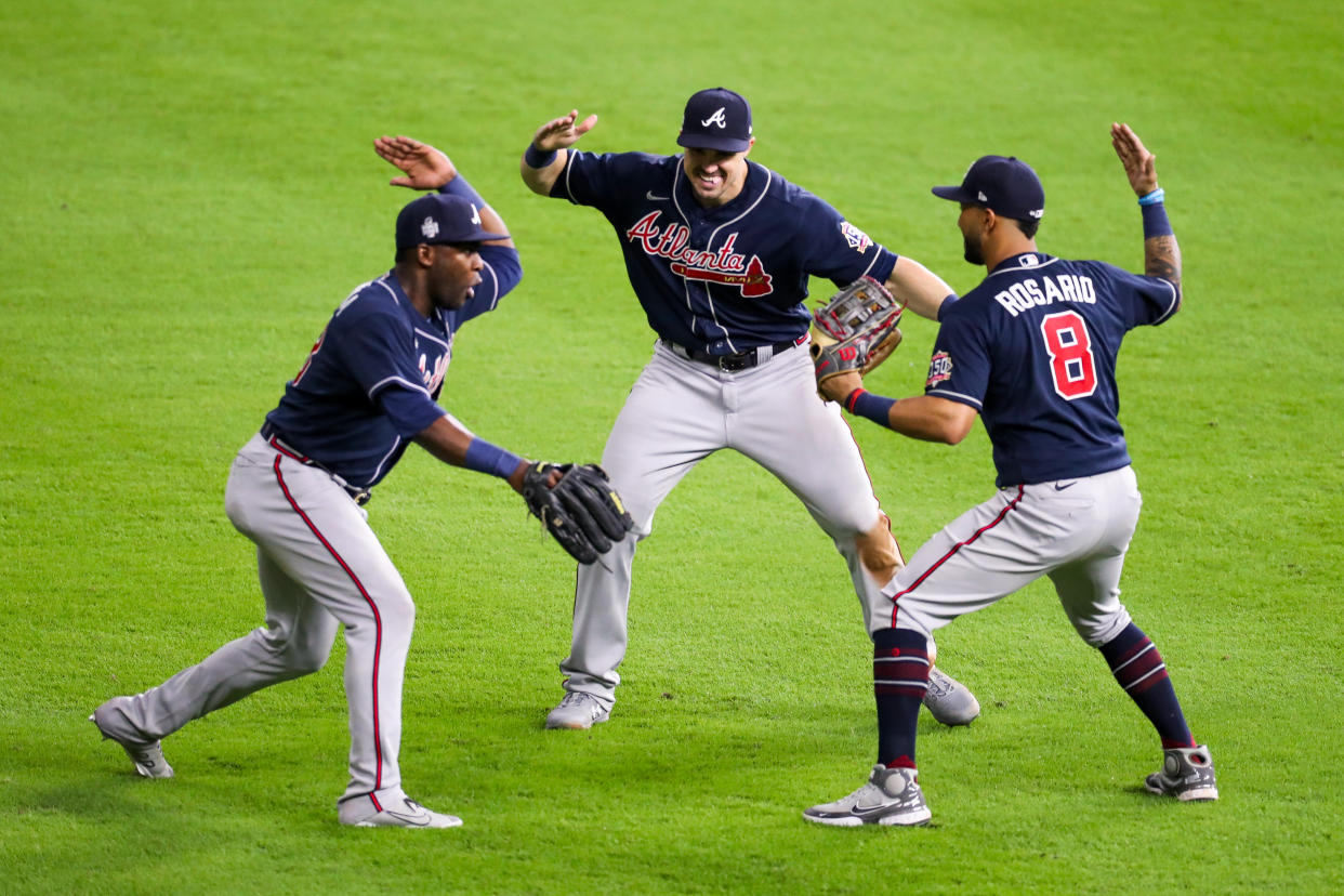 Adam Duvall (14), Guillermo Heredia (38) and Eddie Rosario (8) of the Atlanta Braves celebrate after the final out of Game 1 of the World Series. (Photo by Rob Tringali/MLB Photos via Getty Images)