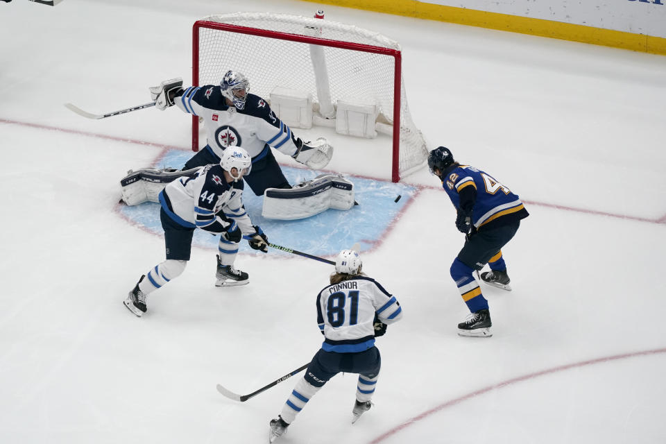 St. Louis Blues right wing Kasperi Kapanen (42) scores past Winnipeg Jets goaltender Connor Hellebuyck as Jets' Josh Morrissey (44) and Kyle Connor (81) watch during the first period of an NHL hockey game Sunday, March 19, 2023, in St. Louis. (AP Photo/Jeff Roberson)