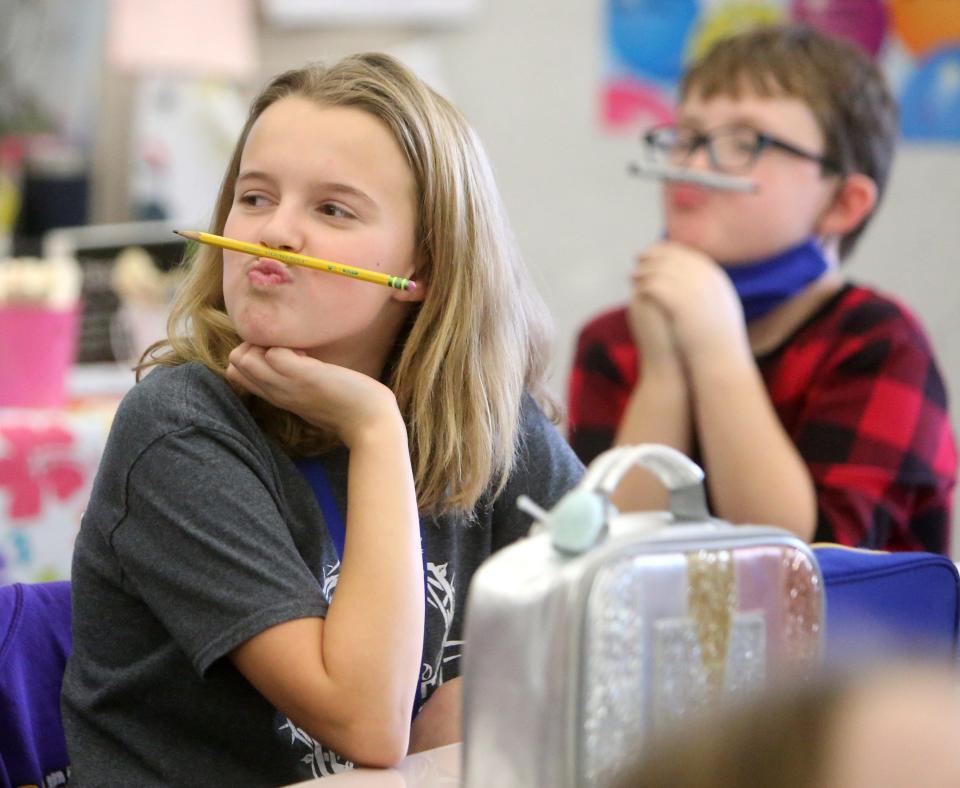 Maelle Douglas and Graham Deluder take a break from creating artwork to make a pencil mustache in their fourth-grade class at Strausser Elementary School in Jackson Township.