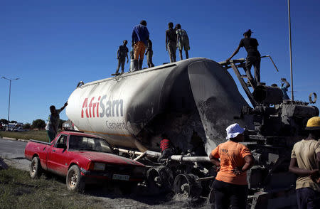 Locals loot cement from an AfriSam cement truck during protests in Mahikeng, North West Province, South Africa, April 20, 2018. REUTERS/Siphiwe Sibeko