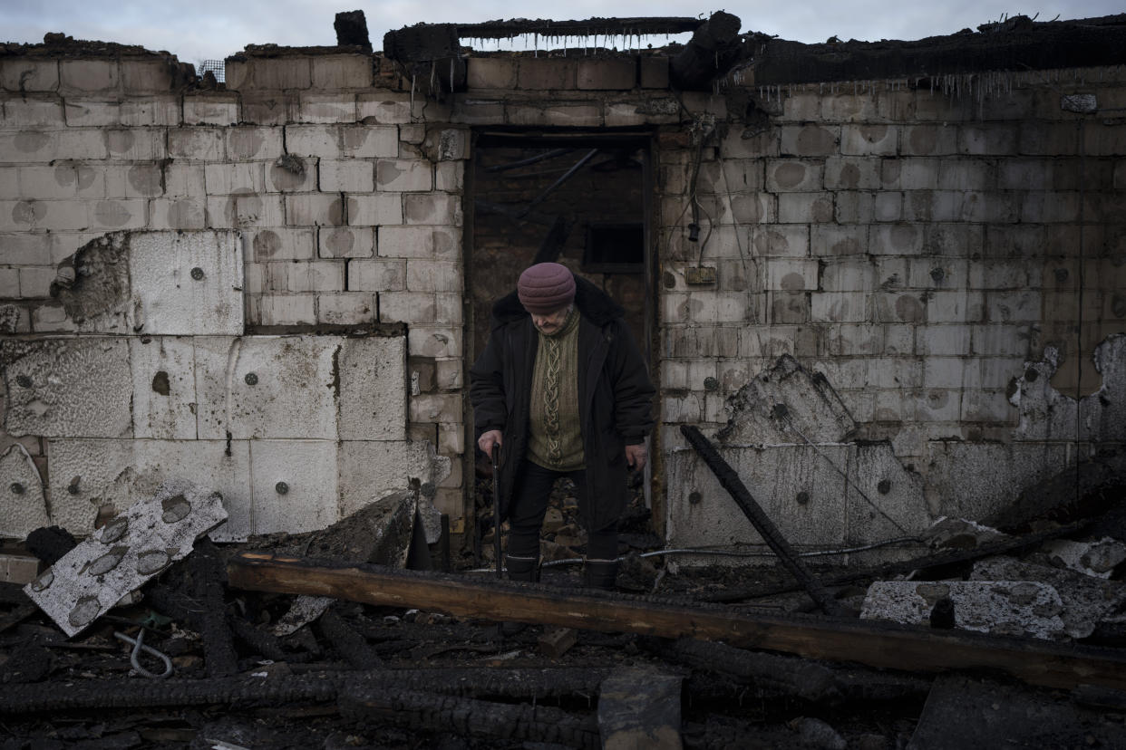 Olha Kobzarenko, 84, searches for her dog Malysh after a Russian drone attack damaged her house in the village of Stari Bezradychi, Kyiv region, Ukraine, Monday, Dec. 19, 2022. (AP Photo/Felipe Dana)