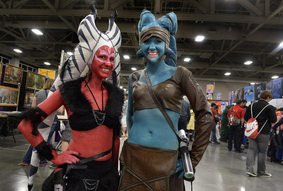 Hope Twede, left as a Sith, and Jessica Johnson, as Jedi "Ayala Secura" pose for a photo on the floor at the opening day of Salt Lake Comic Con, Thursday, April 17, 2014, in Salt Lake City, Utah. (AP Photo/The Salt Lake Tribune, Scott Sommerdorf)