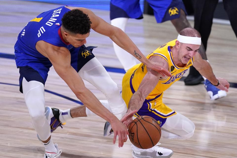 Denver Nuggets' Michael Porter Jr., left, and Los Angeles Lakers' Alex Caruso, right, compete for control of a loose ball during the second half an NBA conference final playoff basketball game, Friday, Sept. 18, 2020, in Lake Buena Vista, Fla. (AP Photo/Mark J. Terrill)